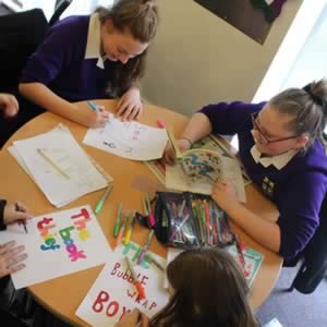 Girls making posters during Book Club enrichment
